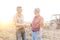 Smiling farmers shaking hands while standing on field at farm