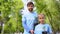 Smiling father and daughter holding green plant saplings, reforestation fund