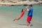 Smiling father and daughter playing together on beach, happy dad and cute little girl playing at seaside