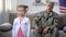 Smiling father military officer looking at grown up daughter with pride, us flag