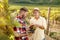 Smiling father and son cutting grapes in vineyard