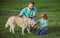 Smiling Father and Son with Pet. Happy Family with Loyal Pedigree Dog have Fun at the Backyard.