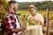 Smiling father vintner showing grapes to son