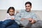 Smiling father watching tv with daughter on the sofa