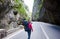 Smiling feamle tourist walking empty mountainous road in spectacular Bicaz canyon in Romania