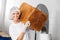 Smiling Female Baker Carrying Big Bread Loaf