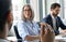 Smiling female ceo looking at male manager colleague at table meeting.