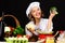 Smiling female chef with broccoli. Healthy food preparation. Cooking in Restaurant. Dieting, vegetarian.
