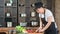 Smiling female chef cuts fresh meat on table preparing food. Wide shot on RED camera