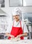 Smiling Female Chef Kneading Dough At Counter