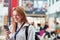 Smiling Female College Student Checking Mobile Phone In Busy Communal Campus Building