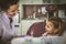 Smiling female dentist make fun with little girl at office.