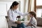 Smiling female doctor cheer small boy patient