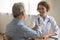 Smiling female doctor handshake mature patient at meeting