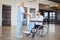 Smiling female doctor handshaking with doctor sitting on wheelchair