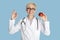 Smiling female doctor nutritionist in glasses and white coat holds red apple and shows okay sign with her hand