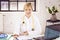 Smiling female doctor working at desk in doctor`s office in the hospital