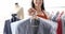 Smiling female dry cleaner holds out clean, ironed suit slow motion 4k movie