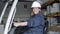 Smiling female employee sitting in forklift in warehouse.