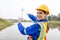 Smiling female engineer of wind turbine energy company. woman pointing forward at station energy power wind. technology protect