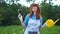 Smiling female gardener posing with zucchini plants and looking at camera, farming and gardening concept