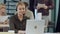 Smiling female helpline operator with headphones at her desk in the office