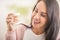 Smiling female looks at the colorful braces on teeth prothesis in her hand