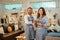 smiling female and male shop assistants in aprons look at the camera