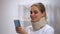 Smiling female in neck collar chatting with friend on smartphone, recovery