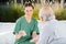 Smiling Female Nurse Playing Cards With Senior Man