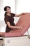 Smiling Female Nurse Washes exam table.