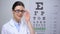 Smiling female optometrist adjusting glasses and looking to camera, professional