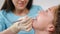 Smiling female orthodontist examining child in dental office. Close-up. Pretty girl with braces on her teeth in modern