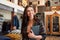 Smiling Female Owner Of Fashion Store Standing In Front Of Clothing Display