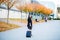 Smiling female passenger proceeding to exit gate pulling suitcase through airport concourse