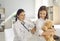 Smiling female pediatrician examining lungs of little girl during medical checkup