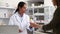 Smiling female pharmacist handing drugs to a customer