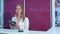 Smiling female receptionist with tablet welcoming hotel guests