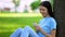 Smiling female scrolling social network app sitting outdoors, online messenger