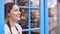 Smiling Female Small Business Owner Standing In Shop Doorway On Local High Street