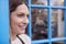 Smiling Female Small Business Owner Standing In Shop Doorway On Local High Street