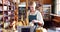 Smiling female staff checking loaf of bread at bread counter