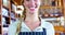 Smiling female staff holding basket of bread at bread counter