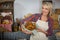 Smiling female staff holding wicker basket of pretzel bread at counter