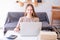 Smiling female teenager studying using her laptop at home