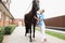 Smiling female veterinarian listens to horse chatter with stethoscope. Providing medical care to animals