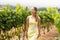 Smiling female vintner looking at grape crop