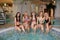 Smiling females relaxing in hot swimming pool in a spa salon