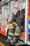 Smiling Fireman Looking At Coffee Mug While In Truck