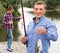 Smiling fisherman holding catch freshwater fish